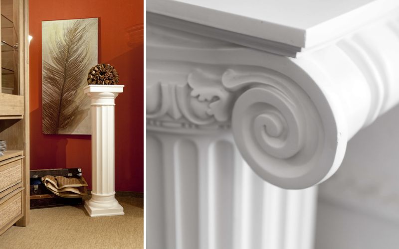 Dekosäulen im klassischen Stil: links eine weiße, kannelierte Säule mit Ablageplatte vor roter Wand und Wohndeko, rechts Detail des ionischen Kapitells mit Volute.
