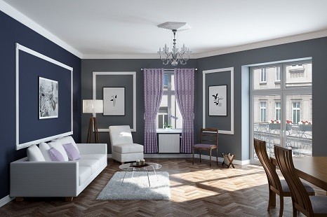 Wohnzimmer mit blau-grauen Wänden und weißen Stuckleisten